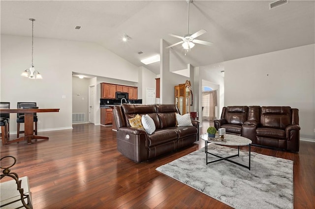 living room featuring dark wood-type flooring, high vaulted ceiling, and ceiling fan with notable chandelier