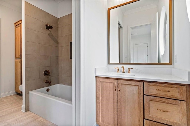 full bathroom featuring tiled shower / bath, vanity, hardwood / wood-style flooring, and toilet