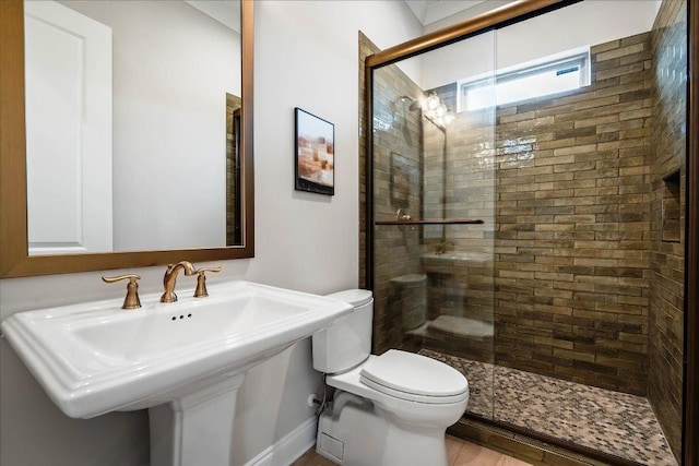 bathroom with walk in shower, sink, and toilet