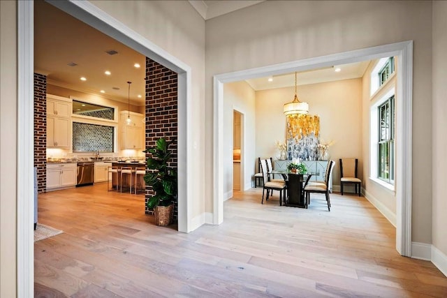 dining space featuring sink, light hardwood / wood-style floors, and a notable chandelier