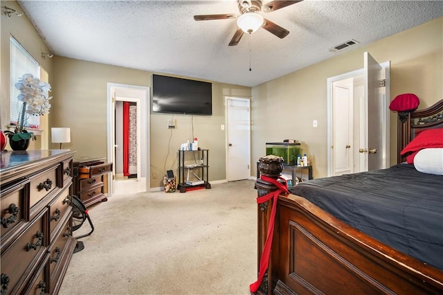 carpeted bedroom featuring ceiling fan and a textured ceiling