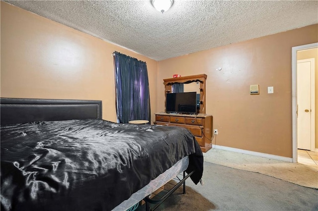 bedroom featuring light colored carpet and a textured ceiling