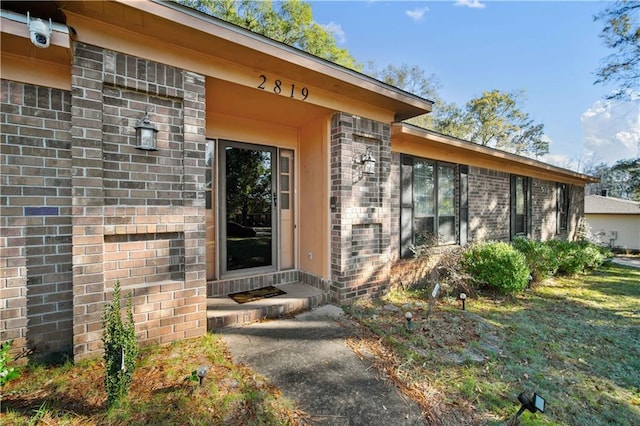 doorway to property with a lawn