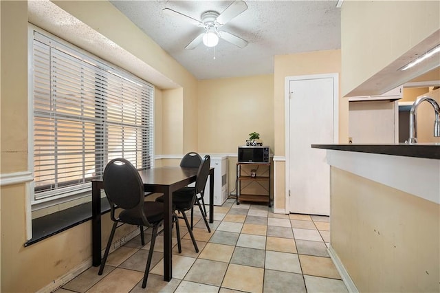 dining space featuring light tile patterned floors, a textured ceiling, ceiling fan, and sink