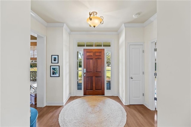 entryway featuring baseboards, light wood-style floors, and ornamental molding