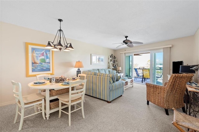 living room featuring carpet and ceiling fan with notable chandelier