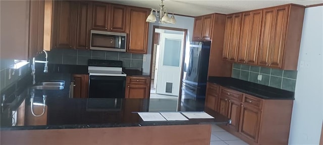 kitchen featuring kitchen peninsula, appliances with stainless steel finishes, sink, and backsplash