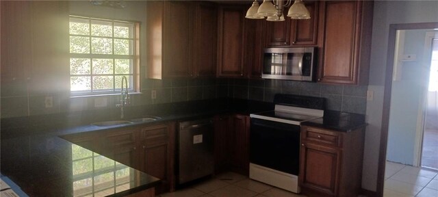 kitchen with appliances with stainless steel finishes, sink, tasteful backsplash, and light tile patterned floors