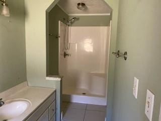 bathroom featuring walk in shower, vanity, and tile patterned floors