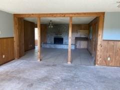 interior space with a fireplace and wood walls