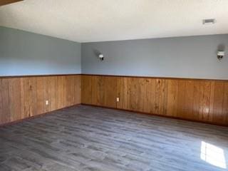 empty room featuring dark hardwood / wood-style flooring and wood walls