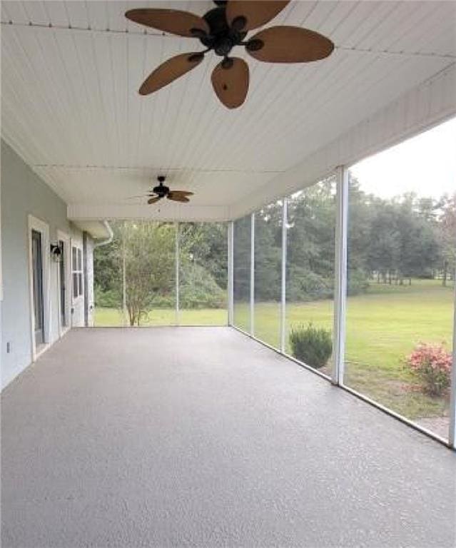 unfurnished sunroom featuring ceiling fan