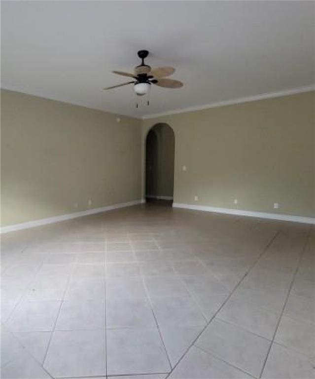 tiled spare room featuring ceiling fan and crown molding