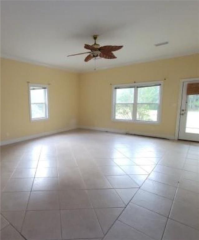 tiled spare room with a wealth of natural light and ceiling fan