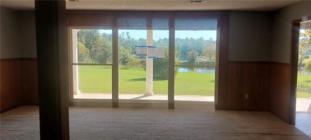 entryway with a textured ceiling, carpet flooring, and a water view