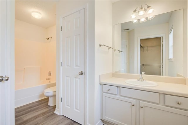 full bathroom featuring vanity, hardwood / wood-style floors, shower / washtub combination, and toilet