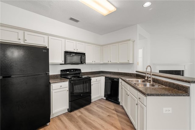 kitchen with white cabinetry, sink, light hardwood / wood-style flooring, and black appliances