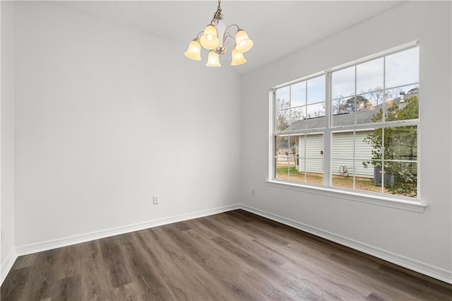 unfurnished dining area with wood-type flooring and an inviting chandelier