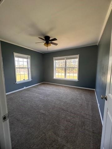 carpeted spare room featuring a wealth of natural light, crown molding, and ceiling fan