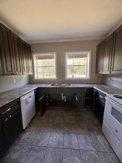 kitchen with white appliances, dark brown cabinetry, and sink