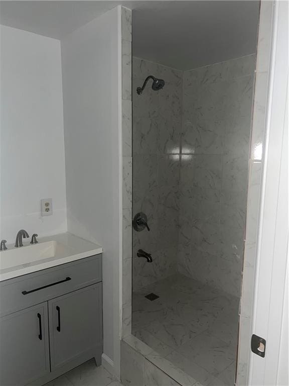 bathroom with vanity and a tile shower