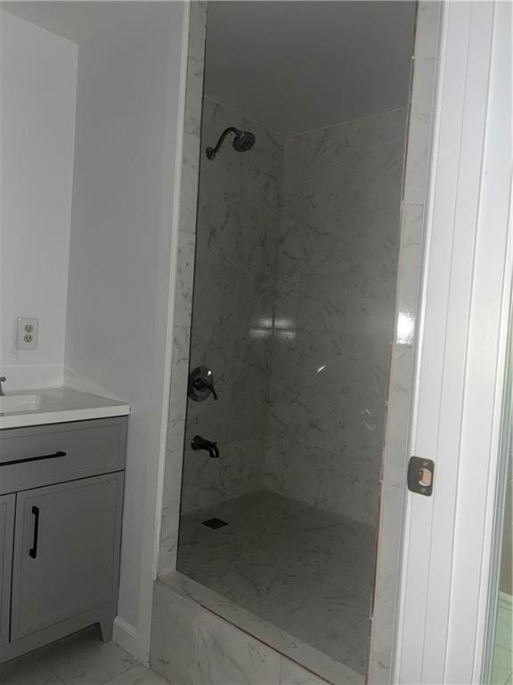 bathroom with tiled shower and vanity