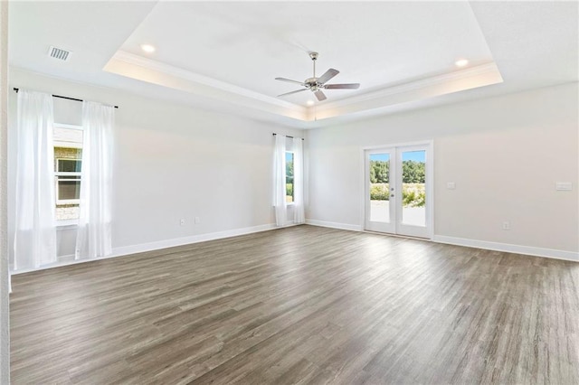 empty room with dark wood-type flooring, a tray ceiling, and french doors