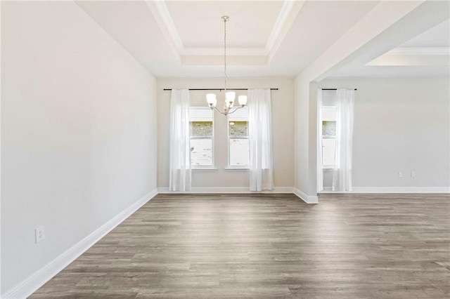 unfurnished dining area with a tray ceiling, hardwood / wood-style floors, and a notable chandelier