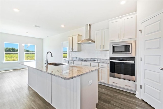 kitchen with backsplash, sink, dark wood-type flooring, wall chimney exhaust hood, and appliances with stainless steel finishes