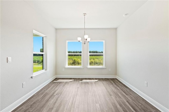 unfurnished room with dark hardwood / wood-style flooring and a chandelier