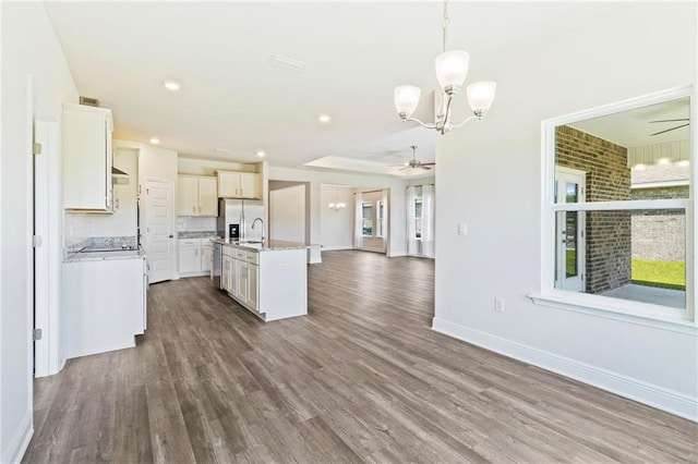 kitchen with ceiling fan with notable chandelier, dark hardwood / wood-style flooring, and a kitchen island with sink