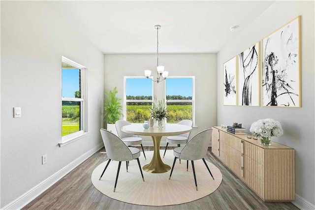 dining area with a healthy amount of sunlight, dark wood finished floors, and a notable chandelier