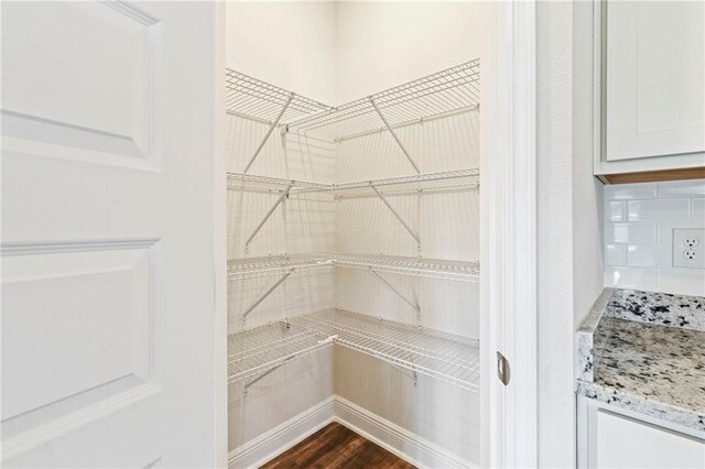 unfurnished bedroom with light hardwood / wood-style flooring, ensuite bath, ceiling fan, and a tray ceiling