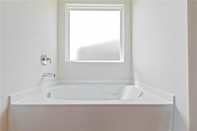 full bathroom with a healthy amount of sunlight and a garden tub