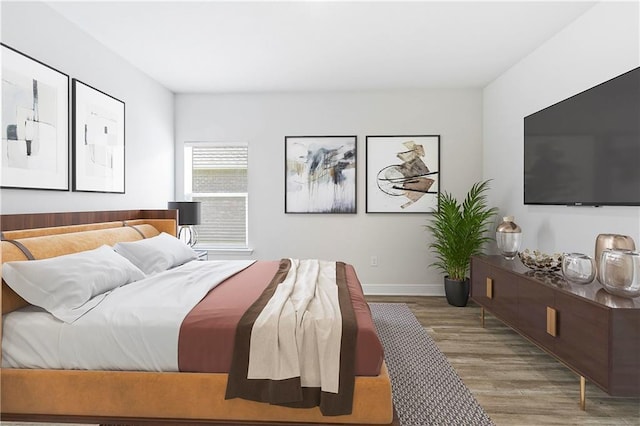 bedroom featuring baseboards and wood finished floors