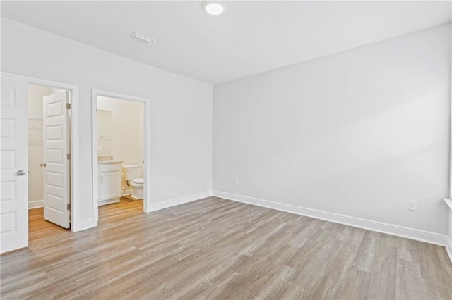 empty room with light wood-type flooring and baseboards