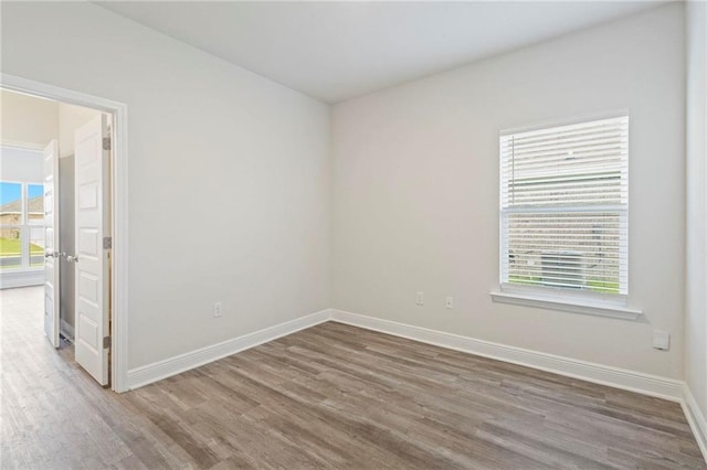 empty room with baseboards and wood finished floors