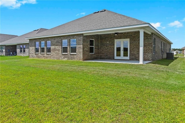 back of property featuring a patio, french doors, a lawn, and brick siding