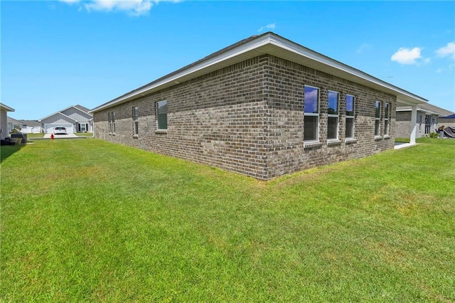 view of property exterior featuring brick siding and a lawn