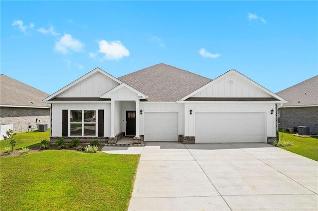 view of front facade featuring a garage, a front yard, and central AC