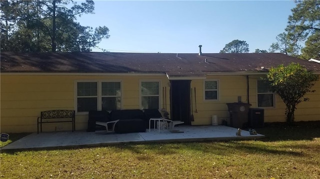 rear view of house with central AC unit, a yard, and a patio area