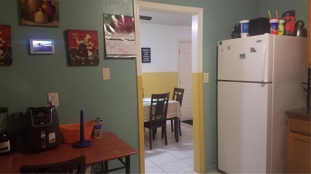 kitchen with light tile patterned flooring and white refrigerator