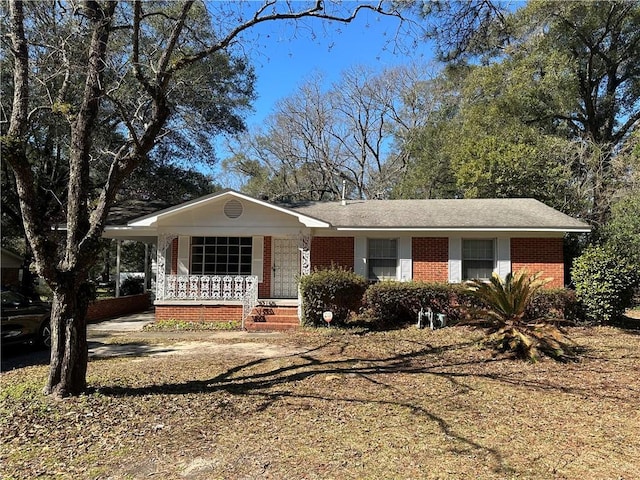 ranch-style home featuring a porch and brick siding