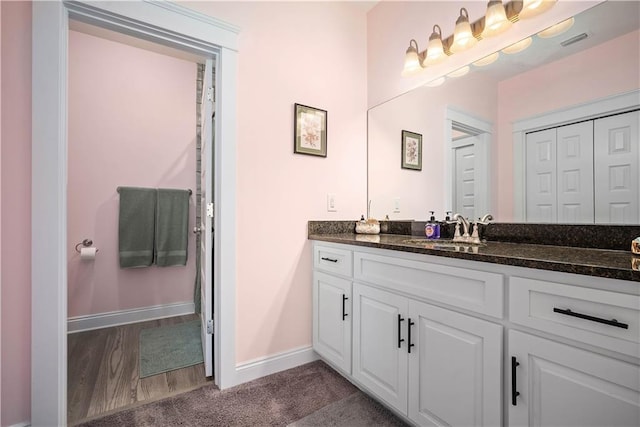 bathroom with vanity, visible vents, and baseboards