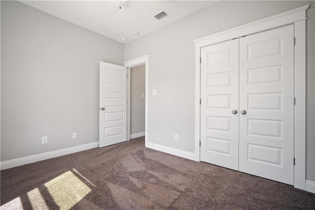 unfurnished bedroom featuring a closet, carpet flooring, visible vents, and baseboards