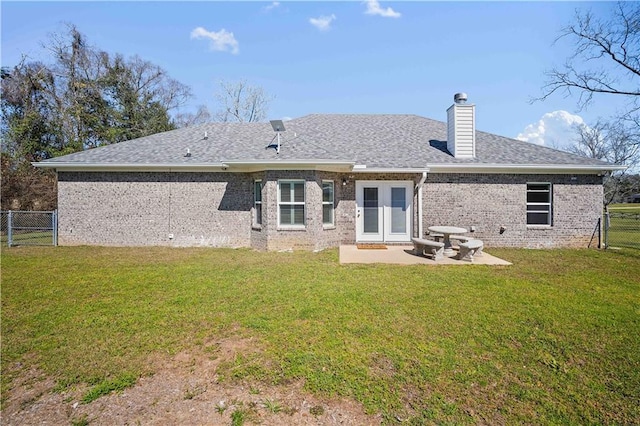 back of house featuring brick siding, fence, a patio, and a lawn