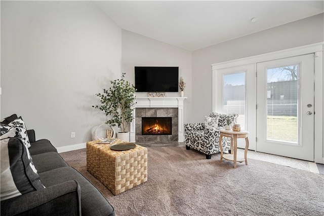 carpeted living room with vaulted ceiling, a fireplace, and baseboards