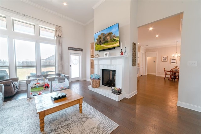 living room featuring dark hardwood / wood-style flooring, a wealth of natural light, and crown molding