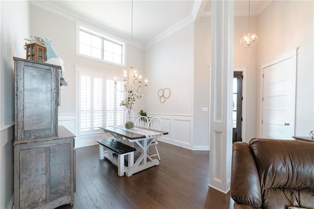 dining room with a towering ceiling, dark hardwood / wood-style floors, an inviting chandelier, and crown molding