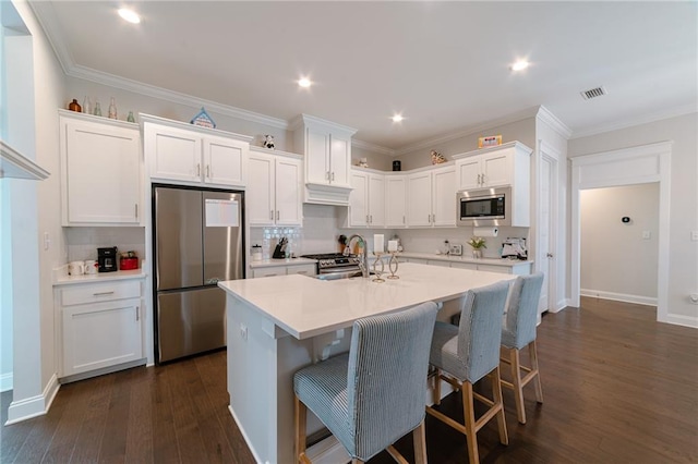 kitchen with sink, stainless steel appliances, dark hardwood / wood-style flooring, an island with sink, and white cabinets